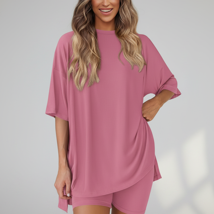 Woman wearing a pink oversized t-shirt and shorts set on a white background
